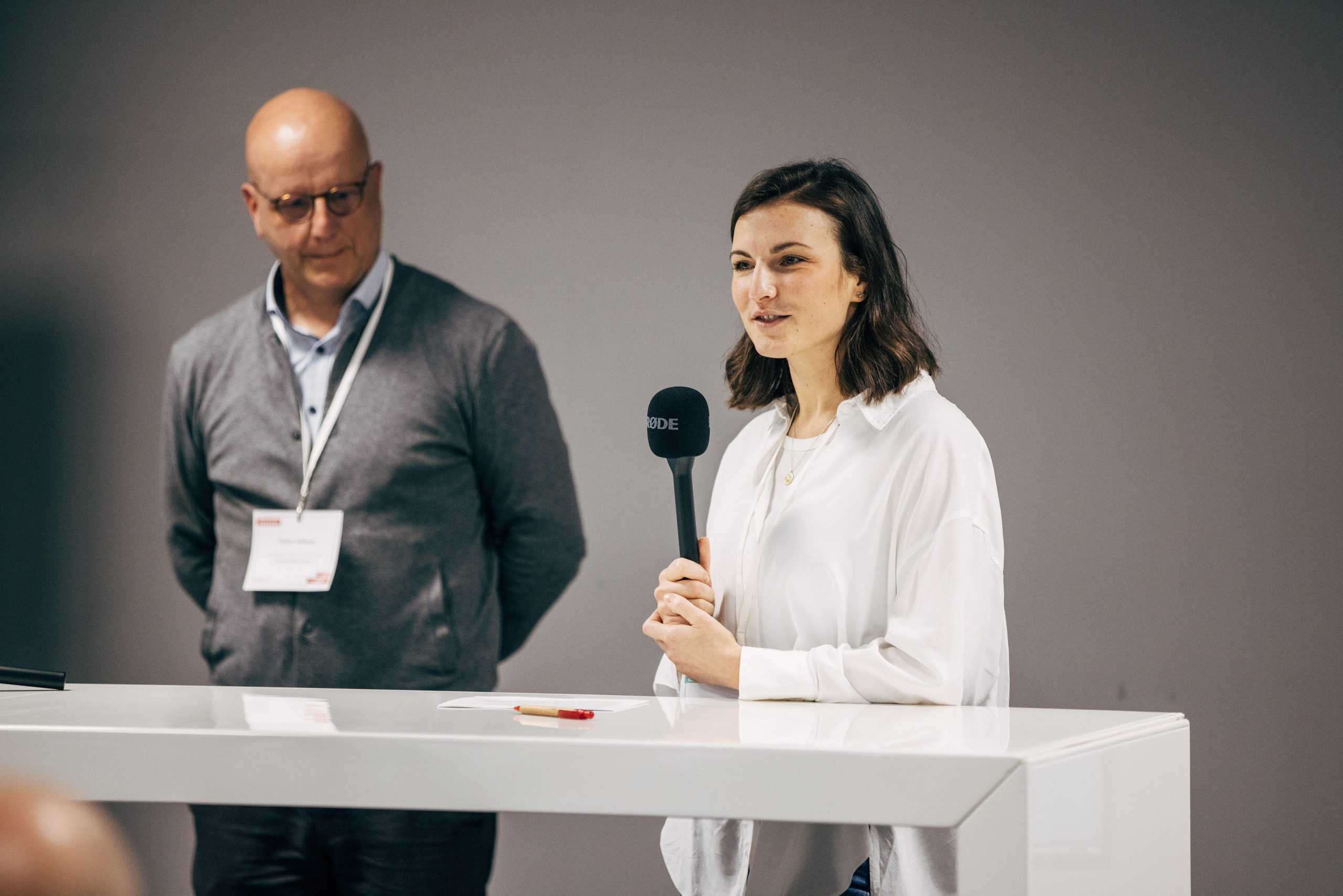 zwei Speaker*innen mit Mikrofon